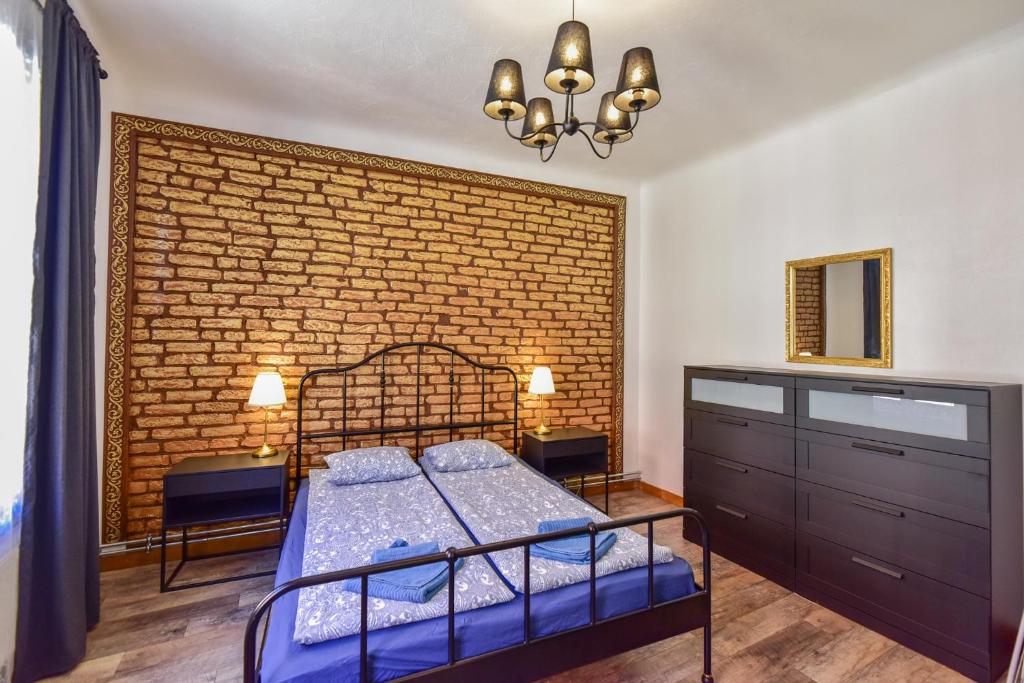 um quarto com uma cama e uma parede de tijolos em VILLA KURLAND em Ventspils