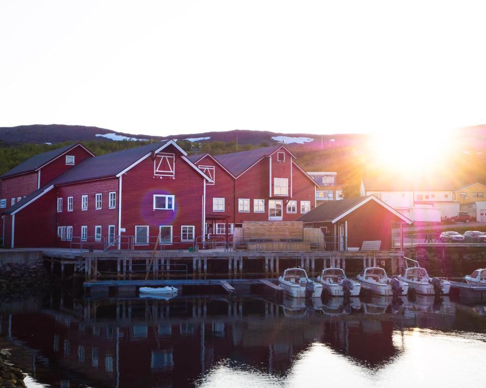 a group of boats docked in front of a red building at Båtsfjord Brygge - Arctic Resort in Båtsfjord