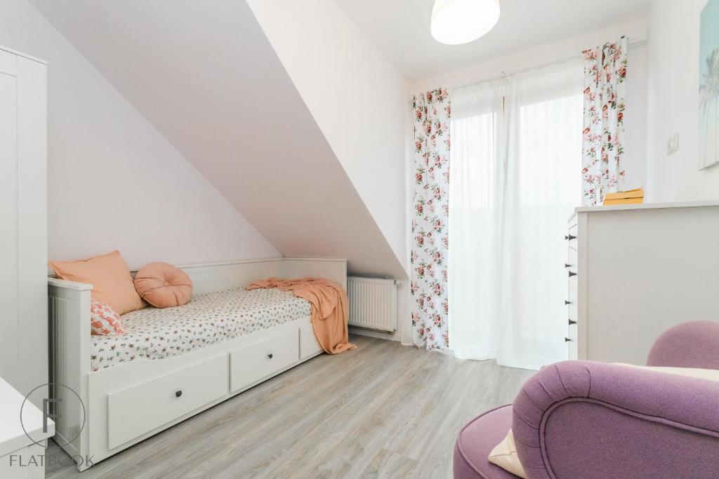 a white bedroom with a bed and a window at Flatbook Apartamenty - Mikoszewo Wczasowa I in Mikoszewo