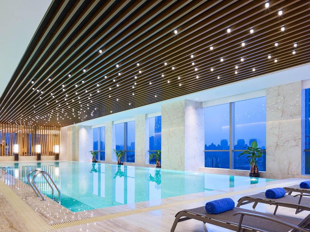 南昌的住宿－南昌萬達嘉華酒店，一座大型游泳池,位于一座带窗户的建筑内