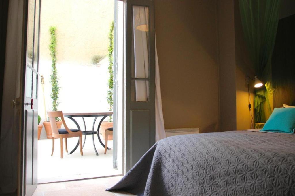 a bedroom with a bed and an open door to a patio at Les Cachettes in Avignon