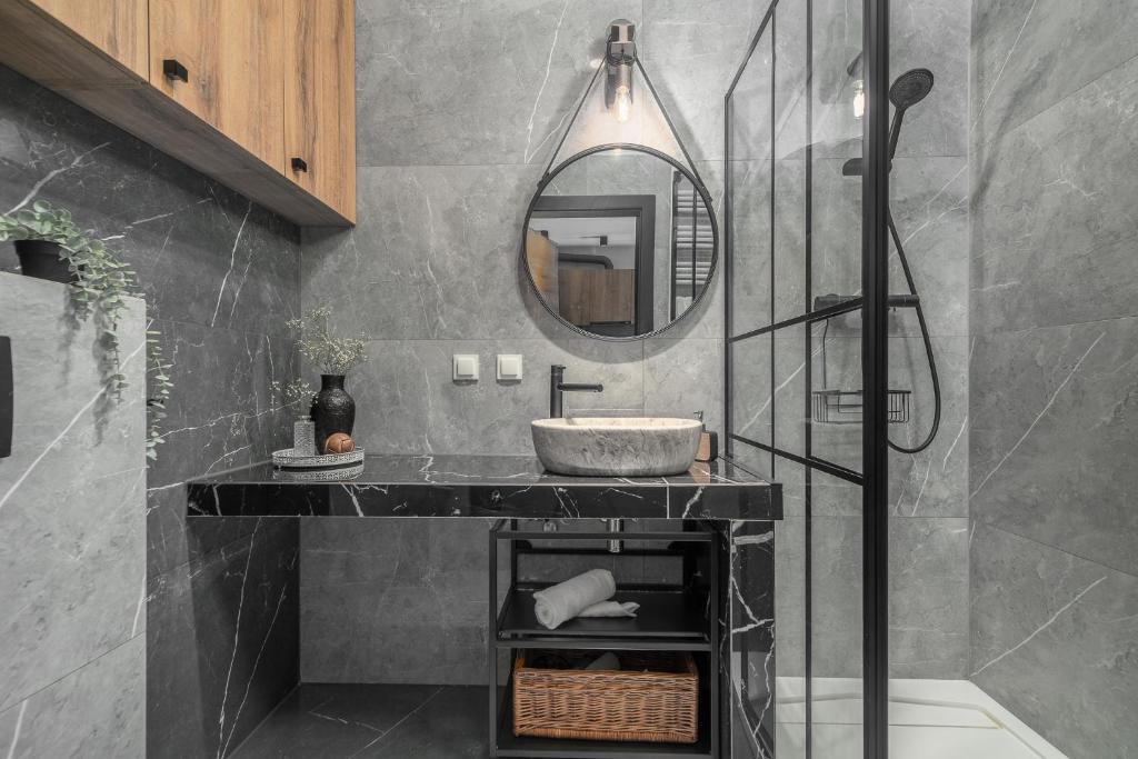 a bathroom with a sink and a mirror at Margi Soho Apartament in Szczecin