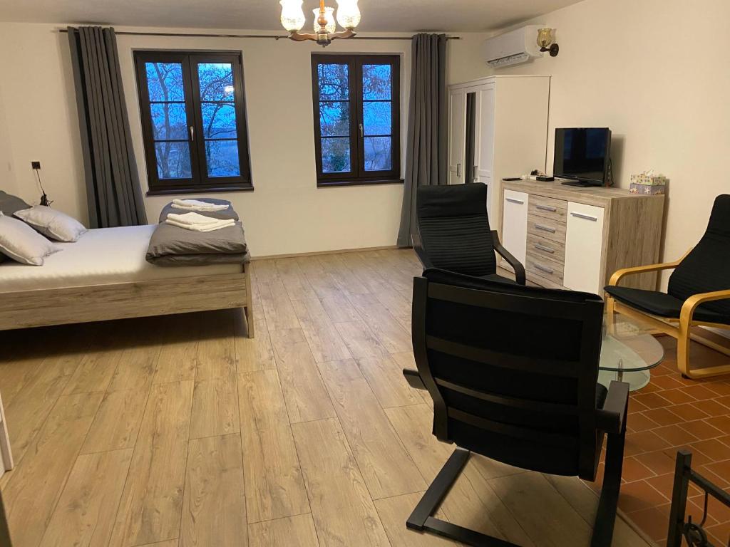 1 dormitorio con 1 cama, mesa y sillas en Apartmán Pod Mandloní, en Starovice