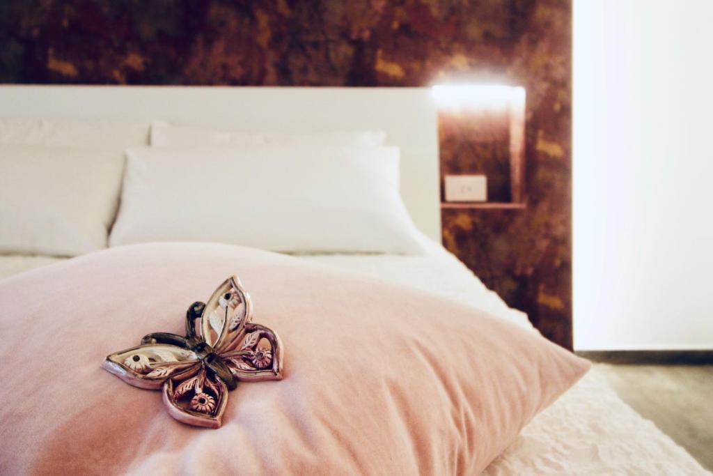 una decoración floral en una cama en un dormitorio en B&B Butterfly Suite, en Bitritto
