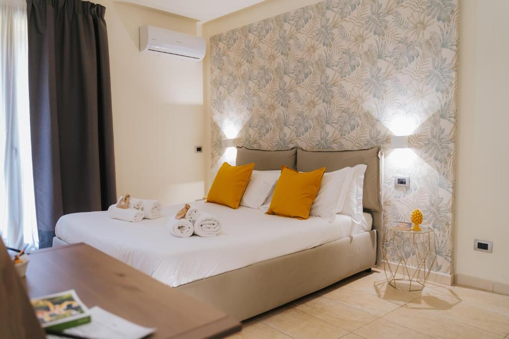 una camera da letto con un letto grande con cuscini gialli di Il Meraviglioso Mondo di Amélie a Agrigento