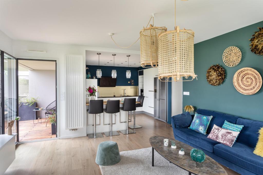 un salon avec un canapé bleu et une table dans l'établissement Le Canal - Appt avec balcon - Vue dégagée en bord de Vilaine, à Rennes