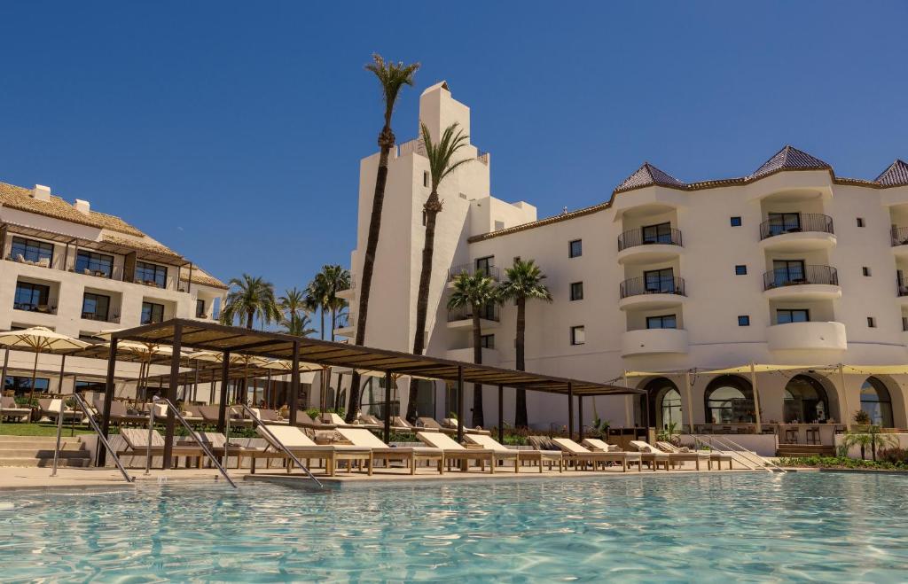 una piscina en un hotel con sillas y edificios en La Zambra Resort GL, part of The Unbound Collection by Hyatt en Mijas