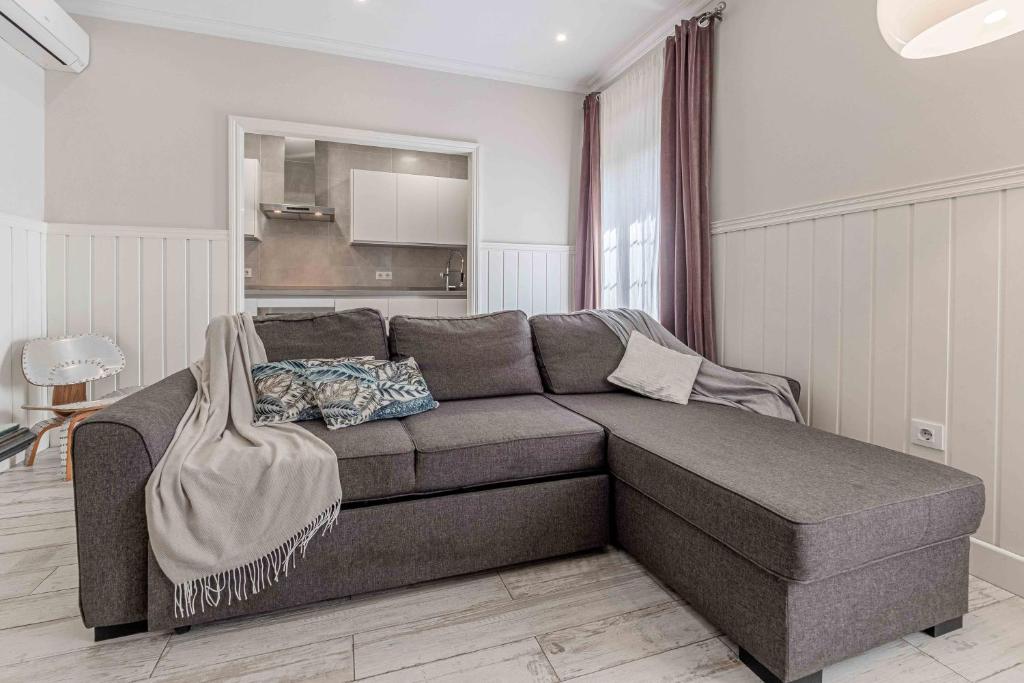 una sala de estar con un sofá marrón en una habitación en Apartamentos Recaredo 7 , 2ª planta, en Sevilla