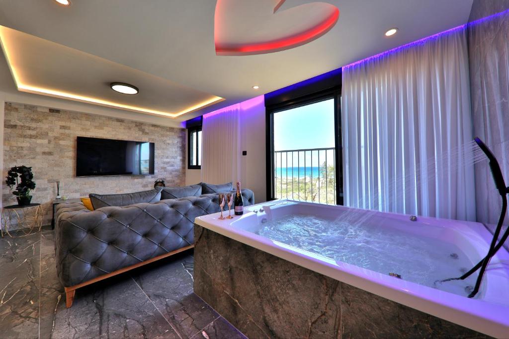 a large tub in a living room with a couch at חלום מול הים - סוויטת נופש יוקרתית עם ג'קוזי ונוף לים in Haifa