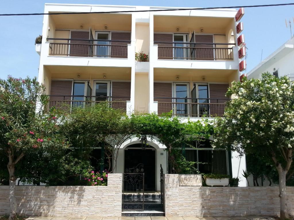 a white building with trees in front of it at Karis Hotel in Kos Town