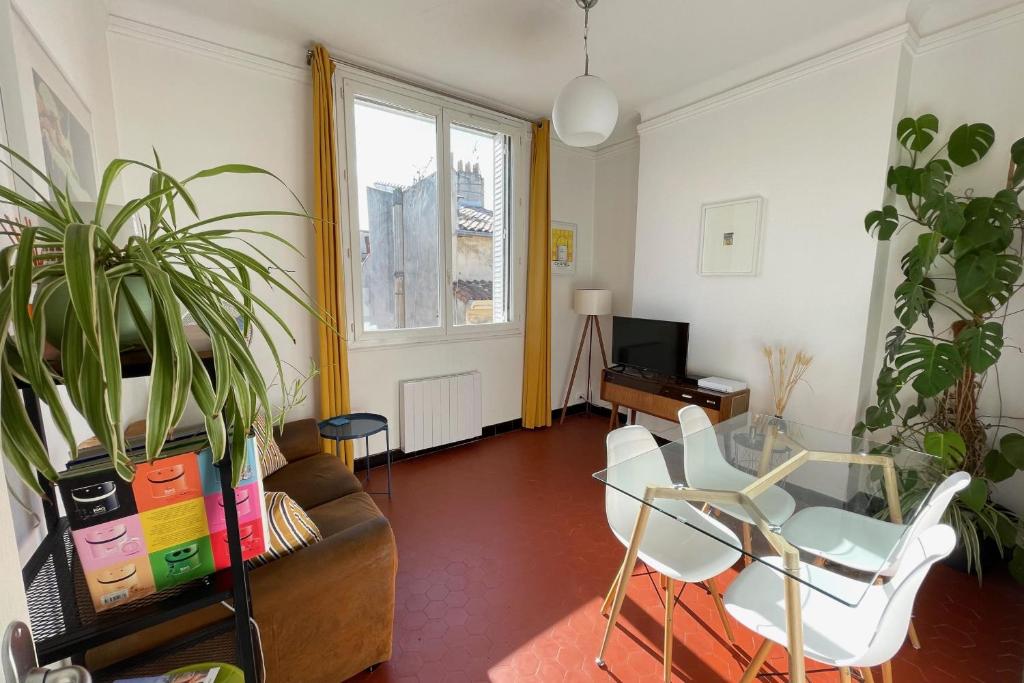 uma sala de estar com um sofá, uma mesa e cadeiras em Beautiful and bright apartment two steps from the Vieux-Port - Air Rental em Marselha
