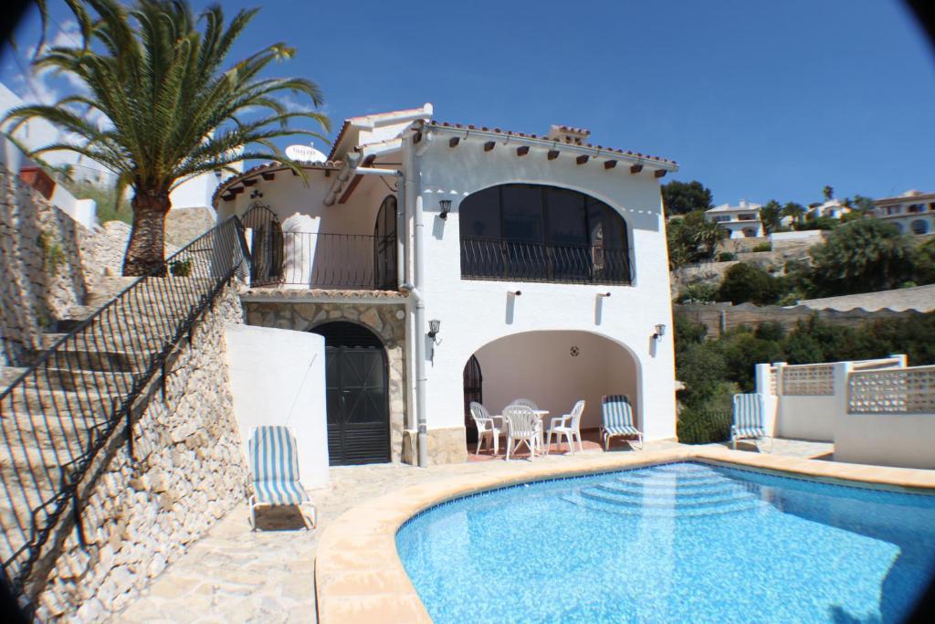 a villa with a swimming pool and a house at Linda - modern villa with splendid views in Benissa in Benissa