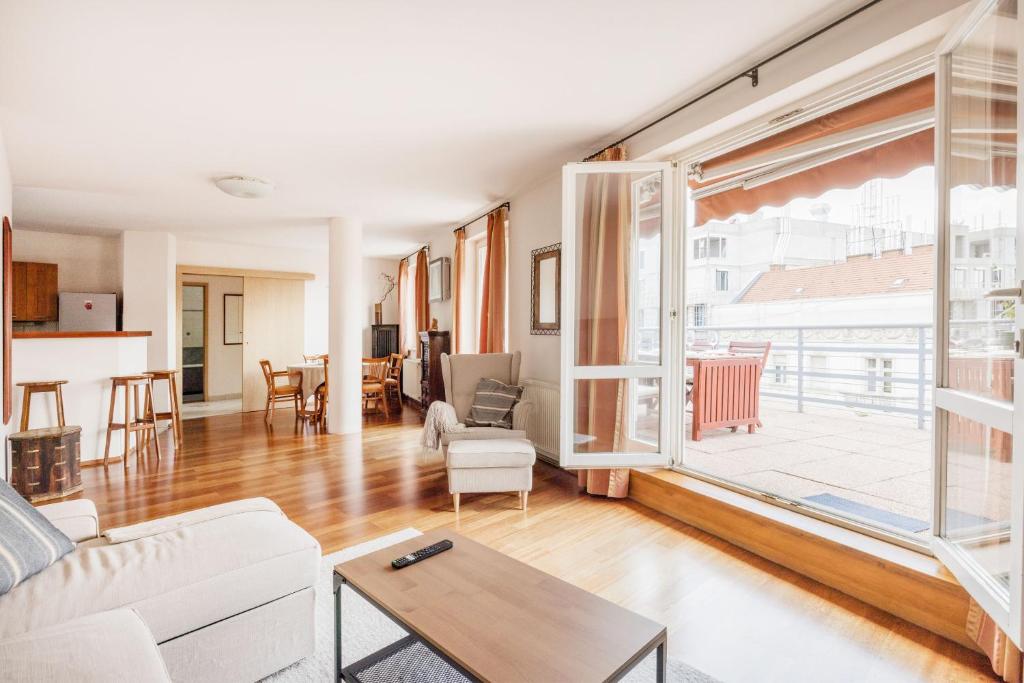 uma sala de estar com um sofá e uma mesa em Bright and Spacious Penthouse w/ Terrace & Parking em Budapeste