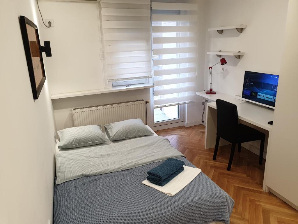 a bedroom with a bed and a desk with a computer at Futoshka Center in Novi Sad