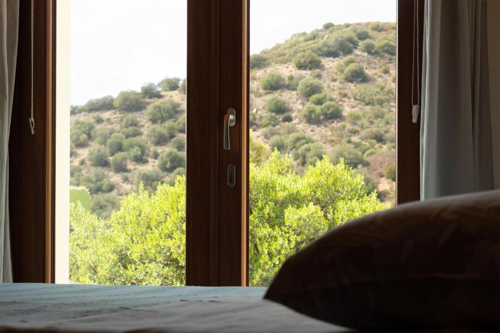 a bedroom with a window with a view of a mountain at Sa Guardia de Ferricci in Solanas
