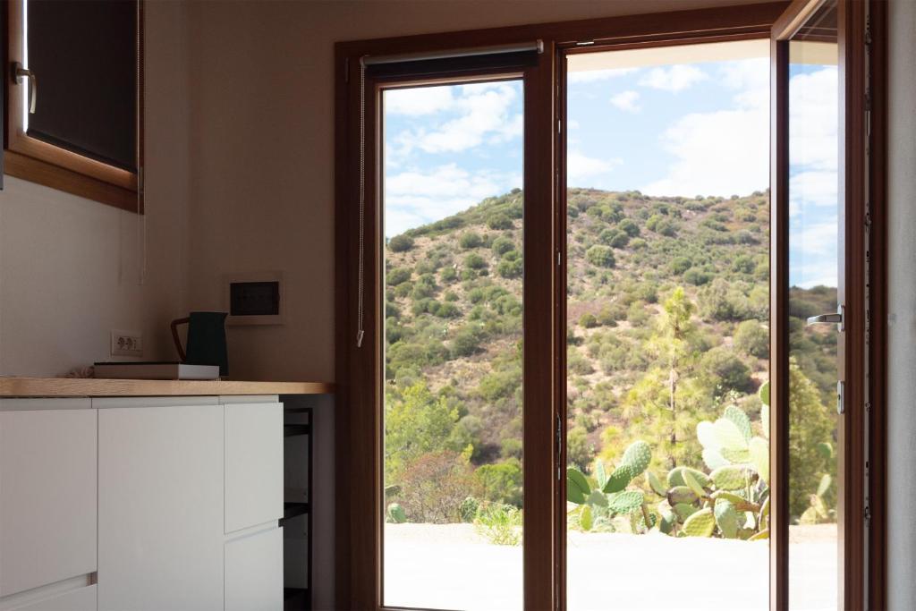 a kitchen with a window with a view of a mountain at Sa Guardia de Ferricci in Solanas