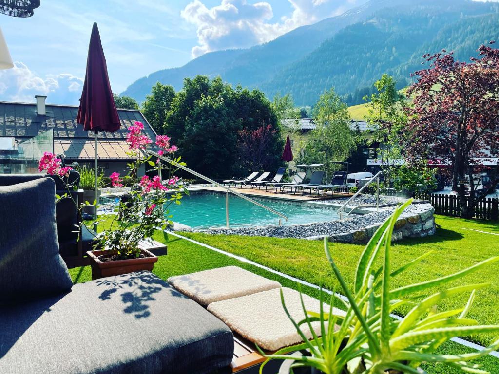 a backyard with a swimming pool and a garden at Hotel Alpenblick in Saalbach-Hinterglemm