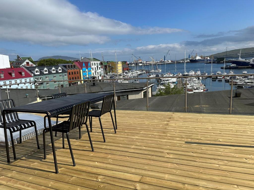 una mesa negra y sillas en una terraza con puerto deportivo en Harbour View / 2BR / City Centre en Tórshavn