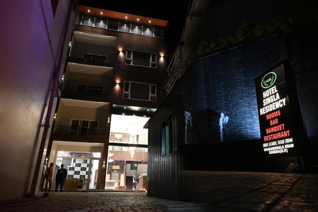 a dark alley with a sign on the side of a building at Hotel Singla Residency in Kangra