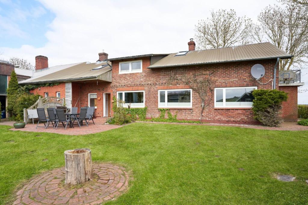 a brick house with a patio and a yard at Ferienhaus Wietblick in Ockholm