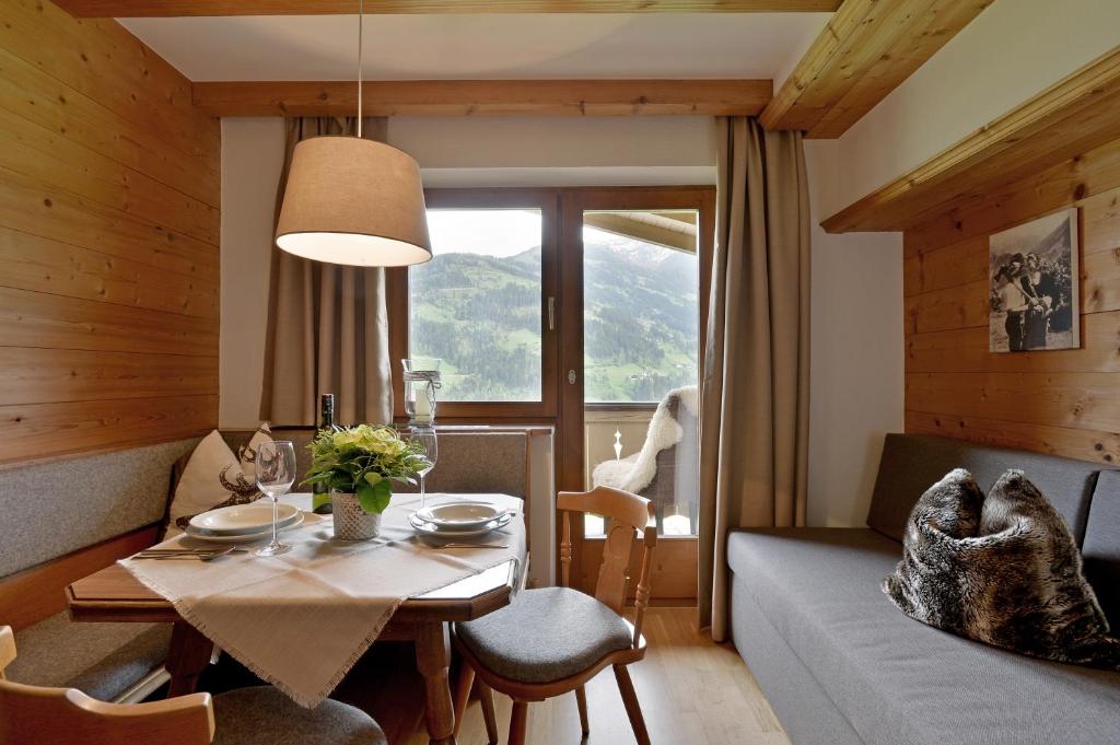 ein Wohnzimmer mit einem Tisch und einem Sofa sowie ein Esszimmer in der Unterkunft Haus Sunnbichl in Hippach