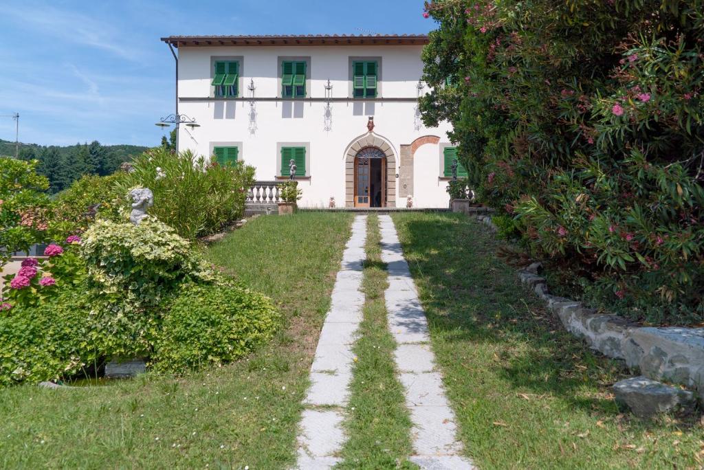 une maison ancienne avec un jardin en face dans l'établissement Villa Castel del Monte, à Pescia