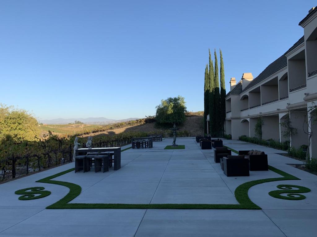 a courtyard with tables and chairs on a sidewalk at Churon Inn Winery in Temecula