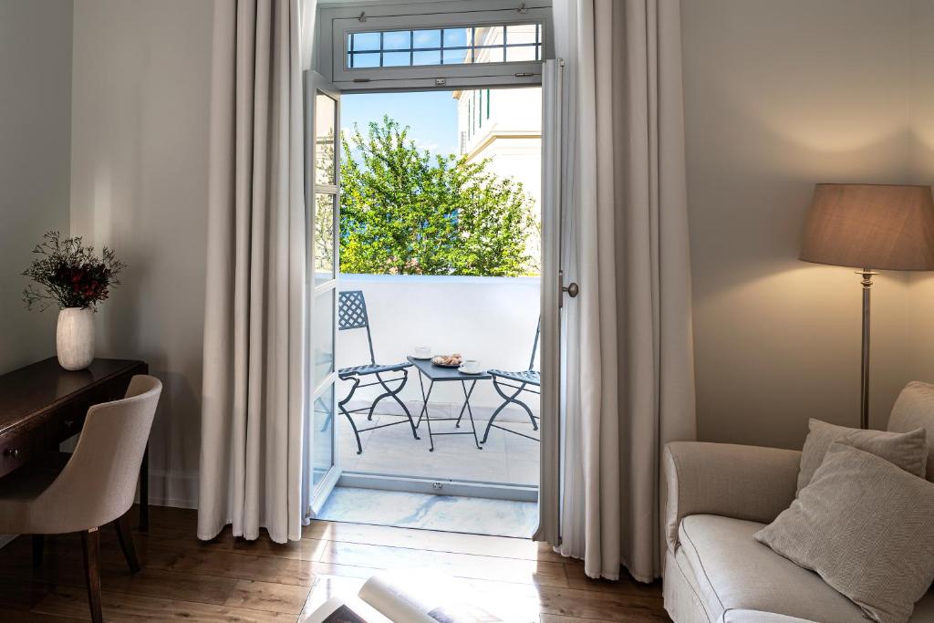 a living room with a door open to a patio at Poseidonion Grand Hotel in Spetses