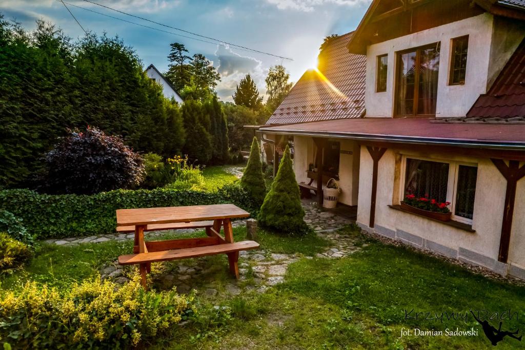 a picnic table in front of a house at Pokoje pod Krzywym Dachem in Karpniki