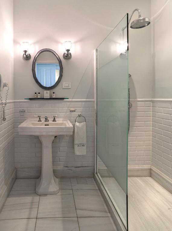 a bathroom with a sink and a glass shower at Poseidonion Grand Hotel in Spetses