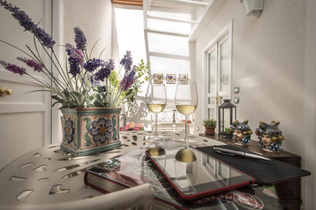un tavolo con due bicchieri di vino e un vaso con fiori di Pane Amore e Marmellata a Palermo