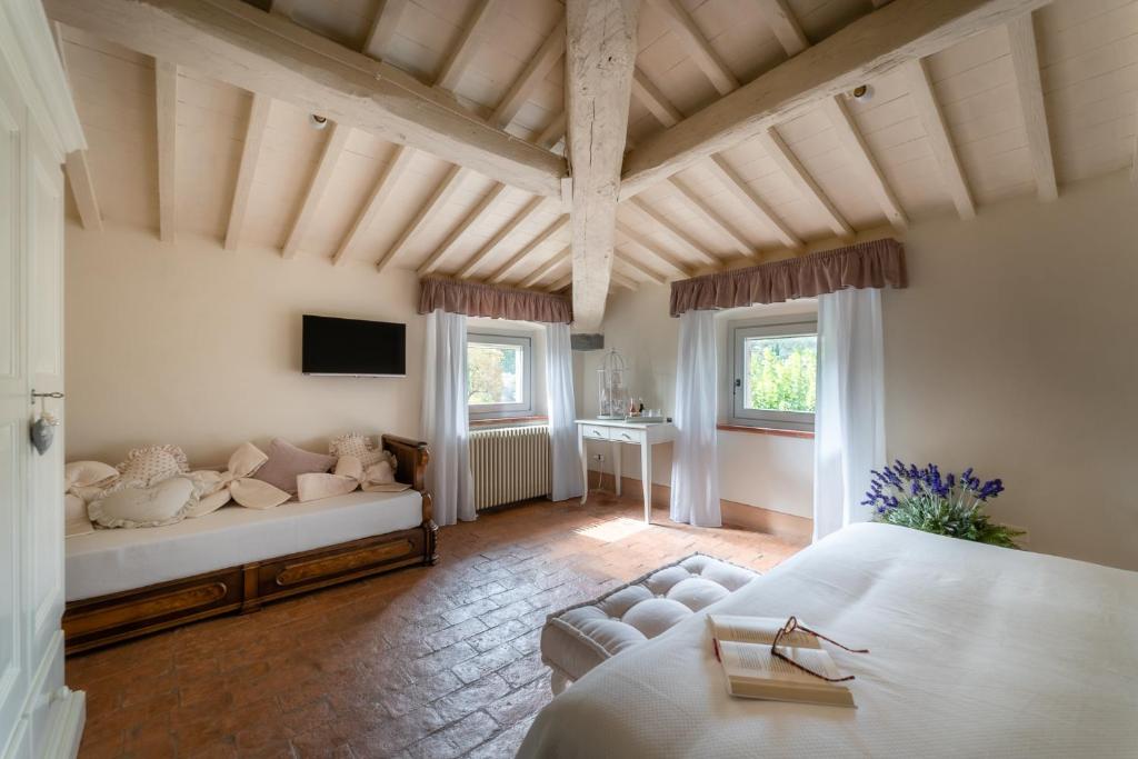 ein Schlafzimmer mit einem Bett und einem Sofa in einem Zimmer in der Unterkunft Relais Maria Cristina in Chianni