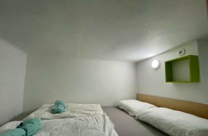 a bedroom with two beds and a tv on the wall at PARIS in Ljubljana
