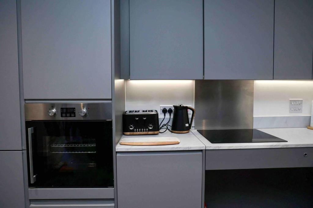 a kitchen with a stove and a toaster oven at Charming 3-Bed Apartment in London in London