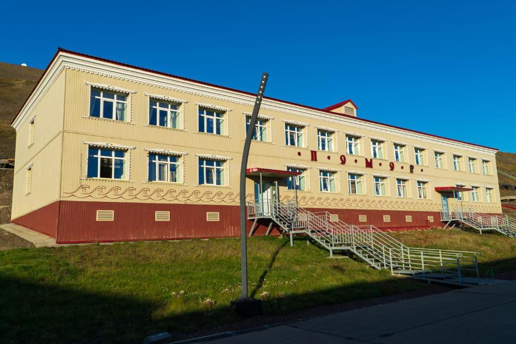 a large building with stairs in front of it at Hostel Pomor in Barentsburg