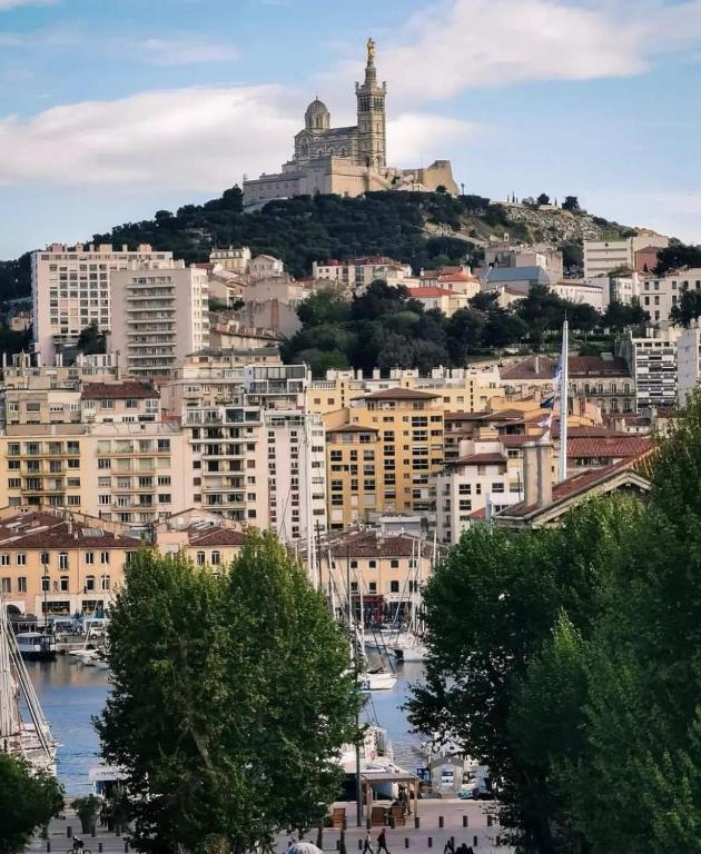 a view of a city with a castle on a hill at Massilia Calling love Appartement de standing 8 personnes Marseille proche métro parking facile in Marseille