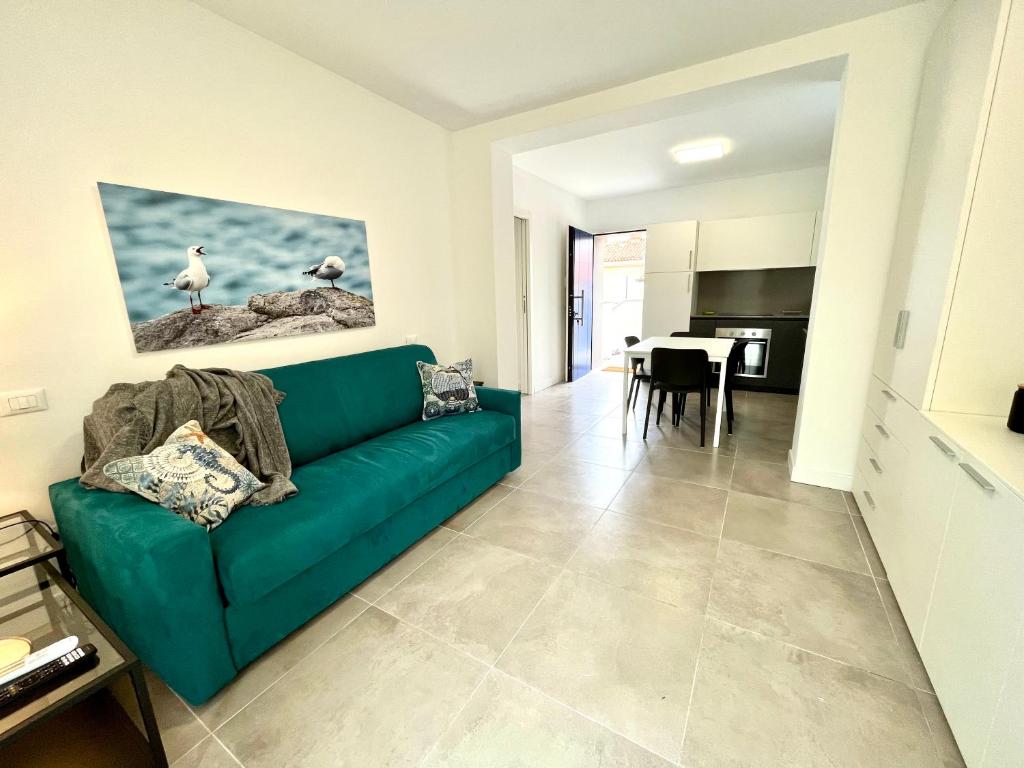 a living room with a green couch and a kitchen at Casa del Groto in Grado