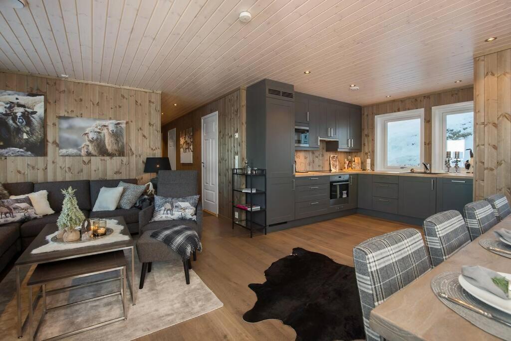 a large living room with a couch and a kitchen at Bualie - Golsfjellet - Biking, swimmming, hiking. High standard. in Gol