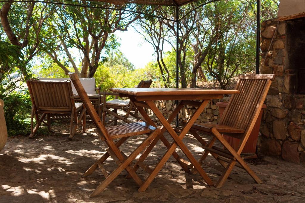 a wooden table and chairs sitting under a tent at Sa Guardia de Ferricci in Solanas