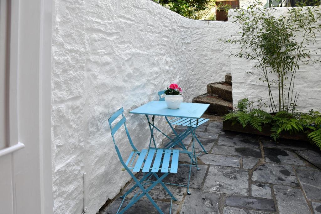 a blue table with a potted plant and a blue chair at The Little Courtyard in Penzance