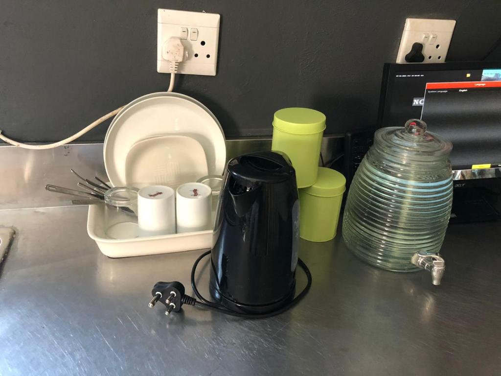a counter top with a blender and cups on it at Beulah group House in Roodepoort