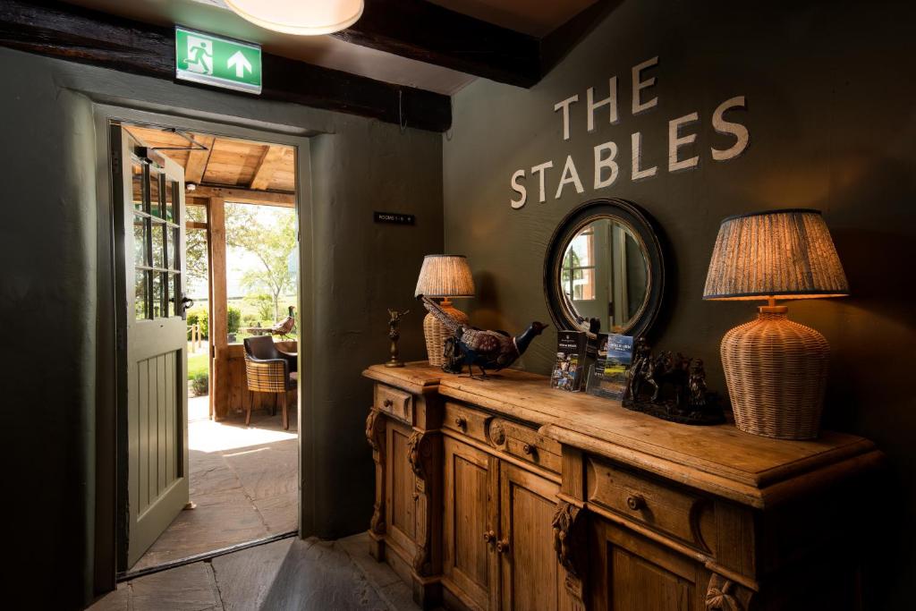 Cette chambre comprend un miroir et une commode en bois. dans l'établissement The Stables - The Inn Collection Group, à Whitby