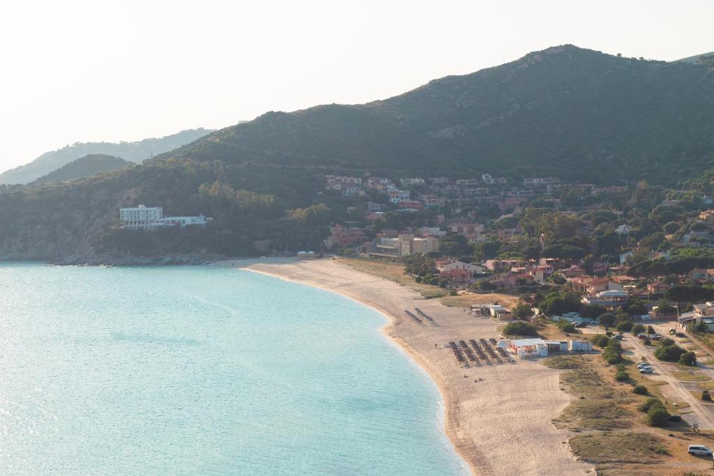 an aerial view of a beach with houses and mountains at Sa Guardia de Ferricci in Solanas