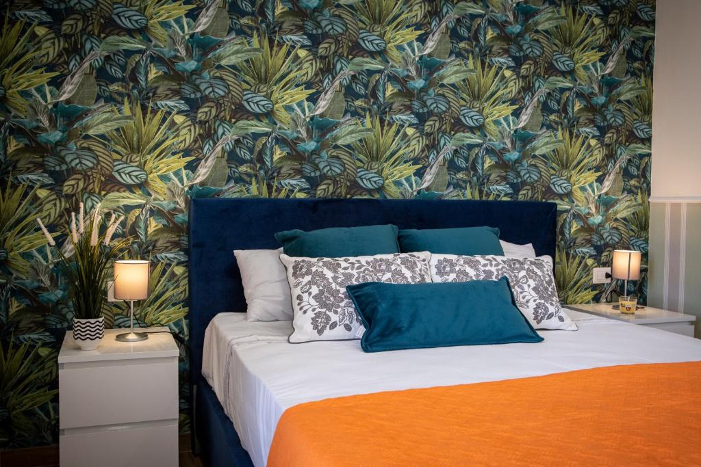 um quarto com uma cama com papel de parede floral em Airport Fly House em Nápoles