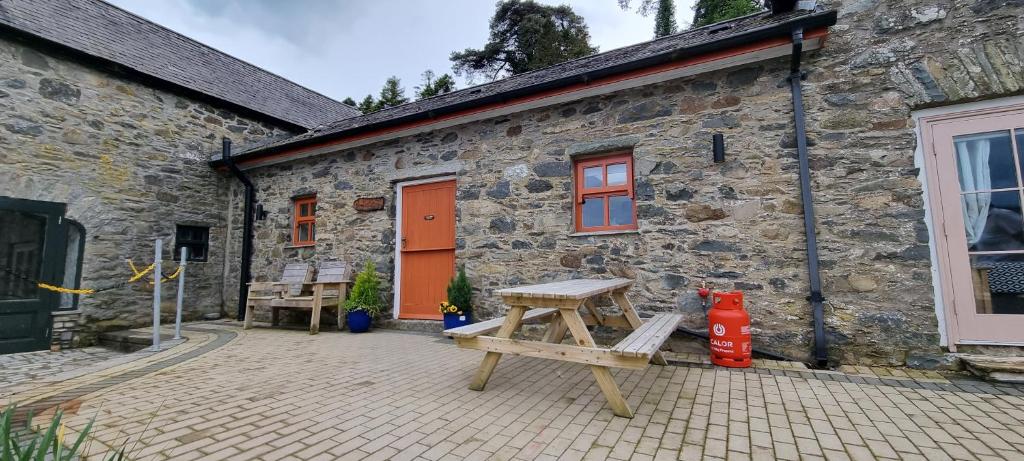 a brick building with a picnic table in front of it at The musical Ceol Cottage 1-Bedroom - Sleeps four in Ballynahinch