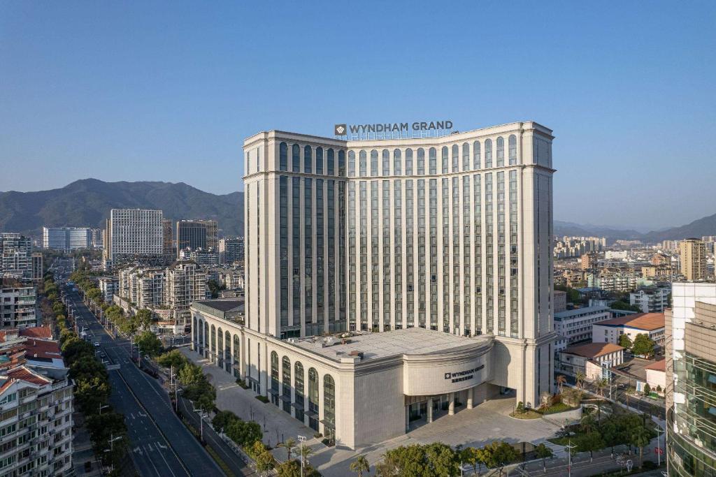 een groot gebouw met een bord erop bij Wyndham Grand Lishui Downtown & Poetry Hotel in Lishui