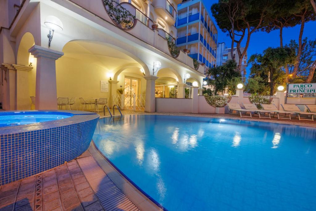 a large swimming pool in a hotel at night at Parco dei Principi Boutique Hotel in Rimini