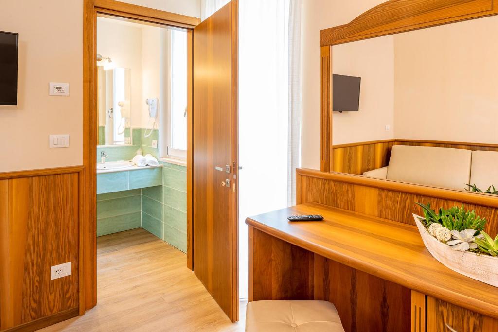 een kamer met een badkamer met een bed en een spiegel bij Hotel Centrale in Garda