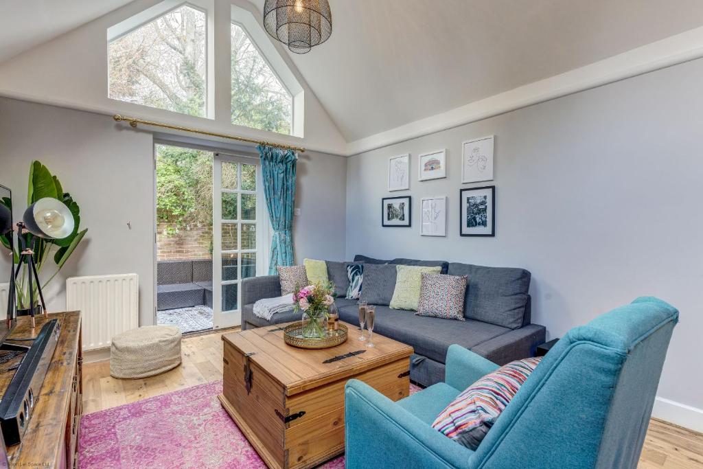 a living room with a blue couch and a table at Apple Tree Cottage in Oxford