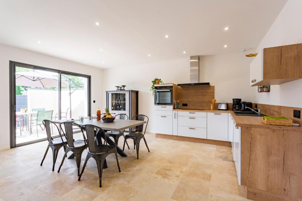 une cuisine et une salle à manger avec une table et des chaises dans l'établissement La Villa de l'Olivier - Maison climatisée pour 6, à Saint-Victor-la-Coste